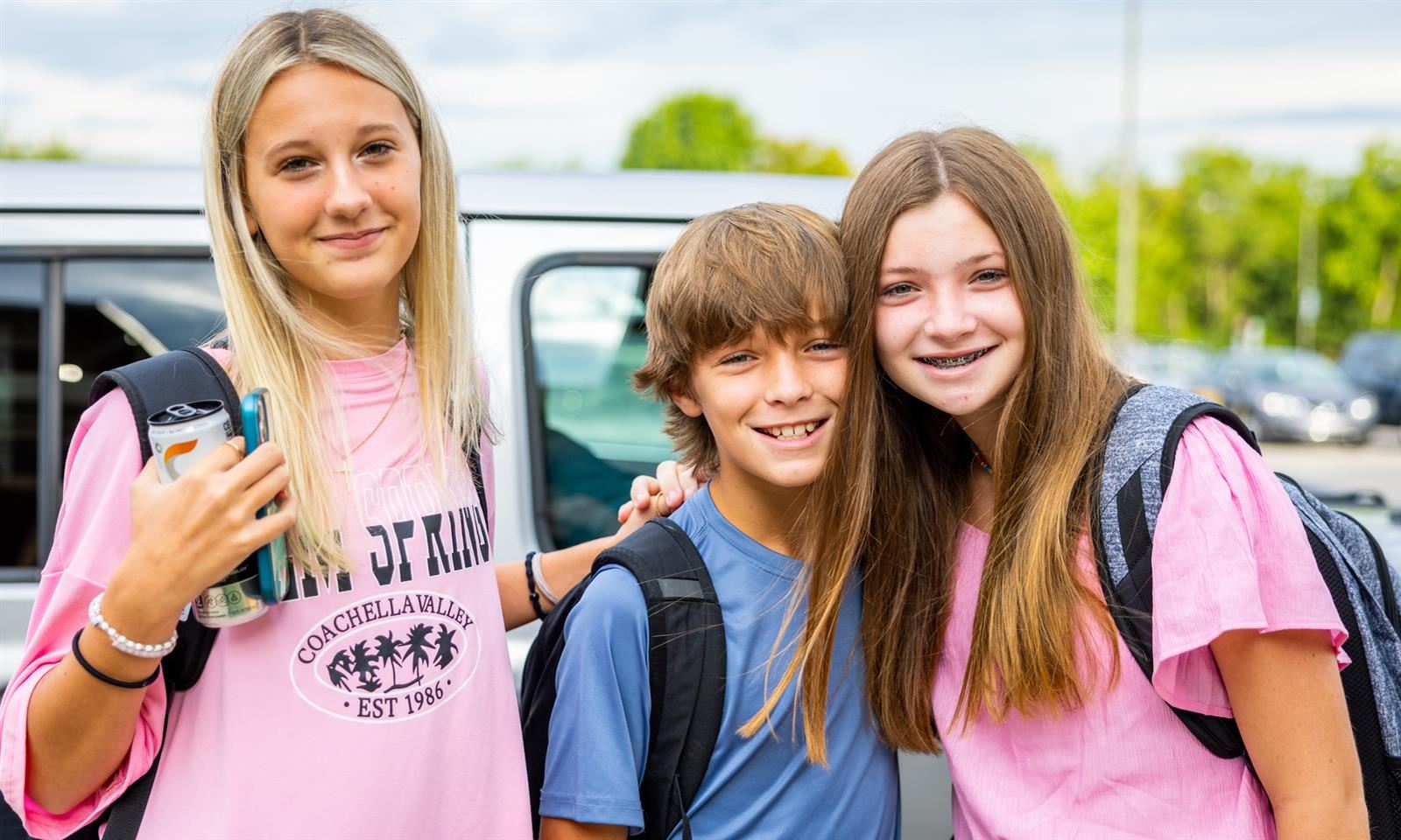 Three students smile
